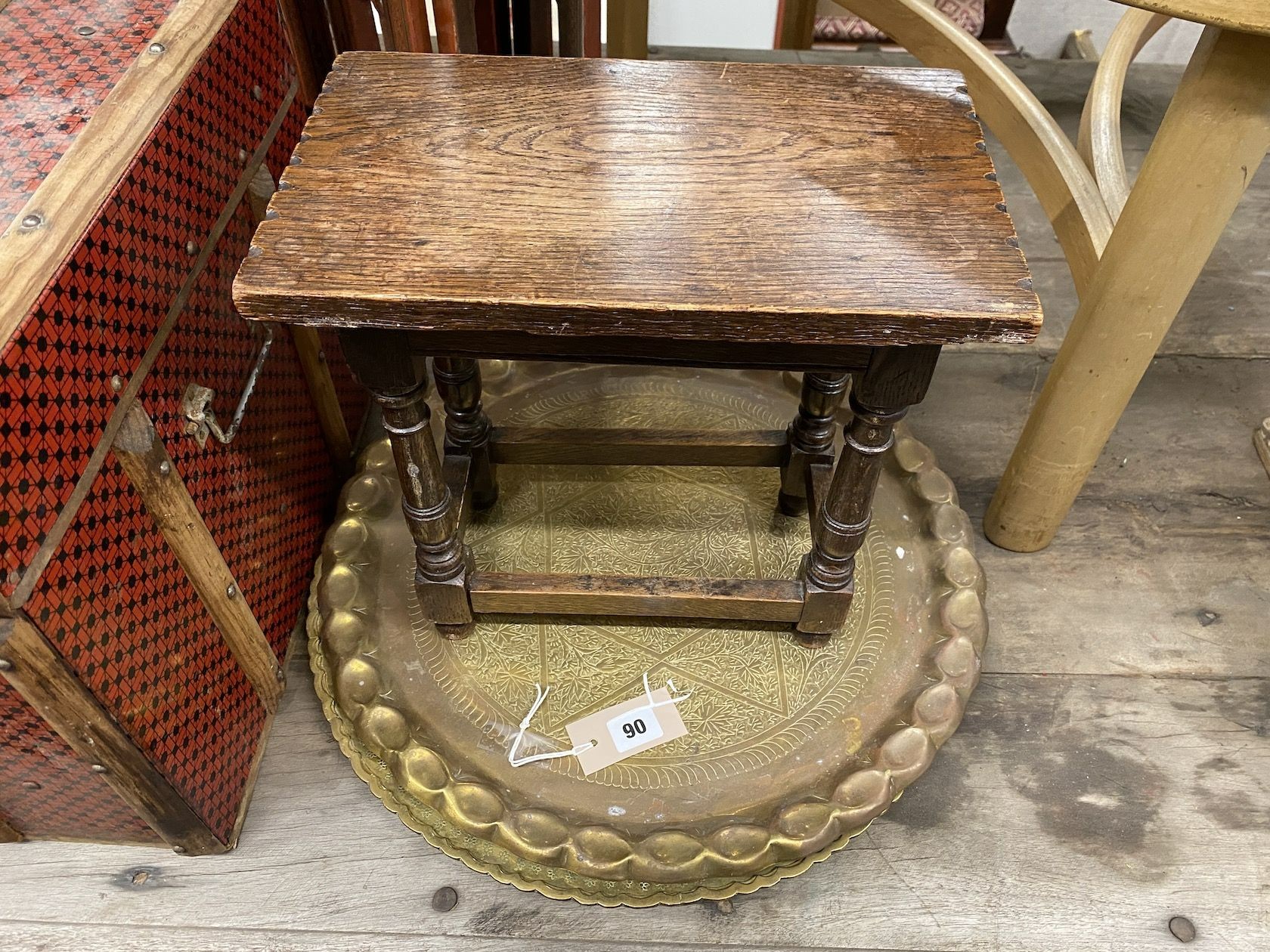 A Chinese lacquer eight fold table screen, height 67cm, an oak stool, and two engraved brass trays and a travelling trunk